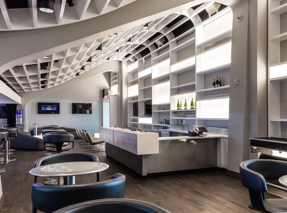 Un salon de l'amphithéâtre de Québec : plafond en treillis blanc, bar et fauteuils de cuir