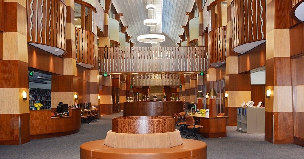 L'atrium de la bibliothèque de l'Université Quinnipiac : colonnes et garde-corps en bois, comptoir circulaire
